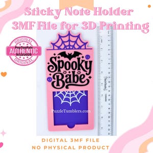 May include: A pink and purple sticky note holder with a Halloween theme. The holder features a bat, spiderweb, and the words "Spooky Babe." A ruler is next to the holder, and the text "PuzzleTumblers.com" is visible.