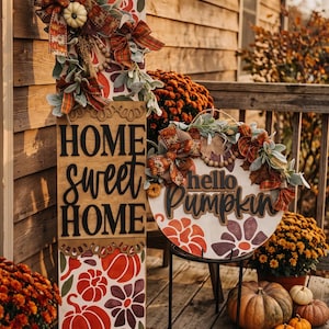 Peut inclure: Un grand panneau en bois rectangulaire avec le texte HOME sweet HOME et un panneau rond en bois avec le texte hello Pumpkin. Les deux panneaux pr&eacute;sentent des motifs de citrouilles et de fleurs peints en rouge et violet, des n&oelig;uds en tissu.