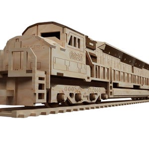 May include: A wooden model of a train engine, featuring the number "6925" and the word "PACIFIC". The model is made of light-colored wood and sits on a wooden track. The design includes detailed cutouts.