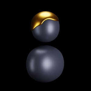 Op de afbeelding: Twee bollen tegen een zwarte achtergrond. De bovenste bol is donkergrijs met een goudkleurige bovenkant. De onderste bol is donkergrijs en reflecteert de bovenste bol. De afbeelding is een digitale weergave.