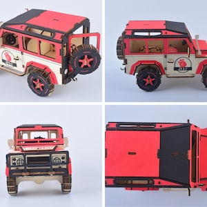May include: A wooden model of a red, black, and cream-colored off-road vehicle. The model has a spare tire on the back and features intricate details. The wheels are black with red star-shaped accents. The model has the text "JP 18" on the side.