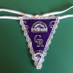 May include: Purple and white lace underwear with a Colorado Rockies logo and the text "Colorado Rockies" and "GR".