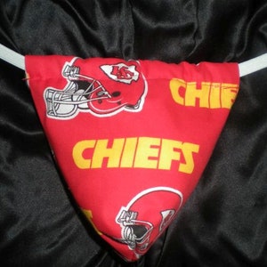 May include: Red and yellow fabric pouch with a white elastic band. The pouch has a pattern of football helmets and the word "CHIEFS" repeated.