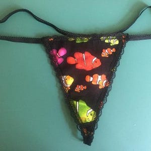 May include: Black lace lingerie with a colorful fish print. The fish are orange, red, yellow, and green.