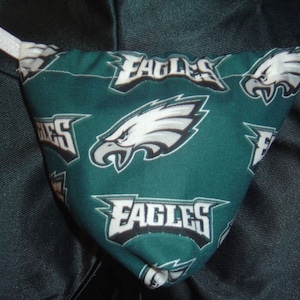 May include: Green fabric with a white elastic band and a repeated pattern of the Philadelphia Eagles logo. The logo is a white eagle with a black outline and the word "Eagles" in black letters.