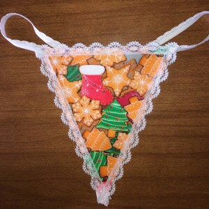 May include: White lace trim underwear with a Christmas-themed print featuring gingerbread cookies, Christmas trees, and a stocking.