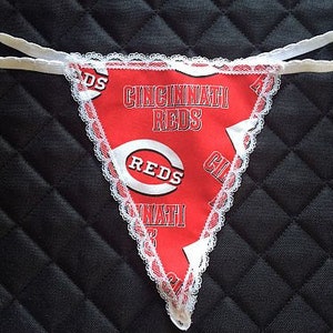 May include: Red and white lace lingerie with a Cincinnati Reds logo and the words "Cincinnati Reds" and "Reds".