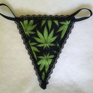 May include: Black lace underwear with a green marijuana leaf print.