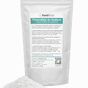Peut inclure: Un sac blanc de thiosulfate de sodium (hyposulfite de sodium) avec un tas de granules cristallins devant. Le sac porte une étiquette avec du texte en français, des instructions et la marque "FertilTech". Le poids net est de 250 g.