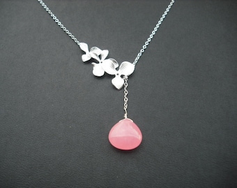May include: A silver necklace with a delicate floral design and a pink gemstone pendant.