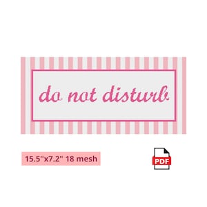 May include: A rectangular needlepoint pattern featuring the text do not disturb in pink cursive letters. The design includes a pink and white vertical striped border and a solid pink frame. The dimensions are 15.5 inches by 7.2 inches at 18 mesh.