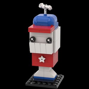 May include: A red, white, and blue Lego figure with a star on the chest and a blue hat. The figure has a white face with black eyes and a wide smile. The figure is standing on a black base.