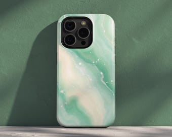 以下が含まれることがあります： 緑と白の色合いで渦巻く抽象的なデザインのスマートフォンケース。ケースは光沢仕上げで、左上隅にカメラの切り抜きがあります。背景は無地のグリーンです。