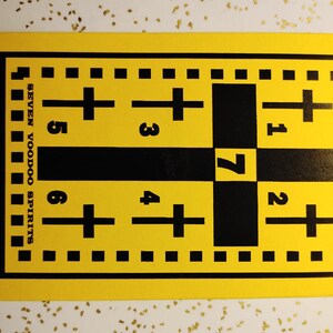 May include: Yellow card with black text and a grid of black crosses and numbers. The text reads "BOSS FIX" and "SEVEN VOODOO SPIRITS".