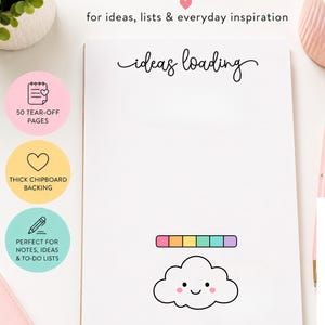 May include: A white rectangular notepad with the text ideas loading in black script at the top. Below the text is a colorful horizontal bar and a smiling cloud graphic with pink cheeks. The notepad features 50 tear-off pages and chipboard backing.