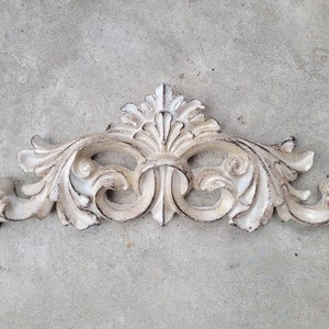 May include: White painted ornate decorative wall decor with a floral design.