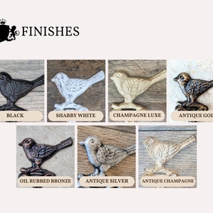 May include: A set of bird-shaped hooks in various finishes, including black, shabby white, champagne luxe, antique gold, oil rubbed bronze, antique silver, and antique champagne. The hooks are displayed on a wooden background.