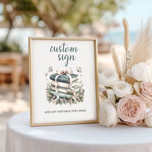 May include: A framed sign with the words "custom sign" in teal script. The sign features a watercolor illustration of stacked books adorned with a bow and butterflies. The bottom of the sign reads "ADD ANY EDITABLE TEXT HERE!"