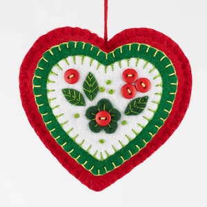 May include: A red felt heart ornament with green felt trim and white felt center. The center features a green felt flower with a red button center and green felt leaves with red button berries.