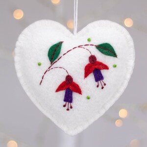 Adorno de corazón de fieltro con flores fucsias bordadas