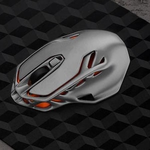 Puede incluir: Un ratón de ordenador plateado con un acento naranja y un diseño futurista.