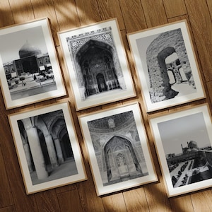 May include: A collection of six rectangular framed wall art prints featuring black and white architectural photography of historic buildings, domes, arched entryways, and stone columns, all displayed in light wood frames on a wooden floor.