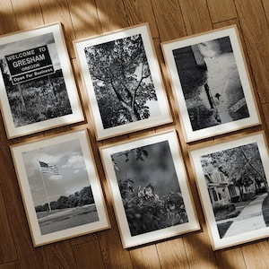 May include: Six framed black and white photographs with wooden frames. The images depict scenes including a sign that reads "Welcome to Gresham Oregon Open For Business", a tree, an American flag, a bird, and a street scene.