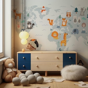 Könnte beinhalten: Ein Kinderzimmer mit hellblauer Weltkarte-Tapete mit Cartoon-Tieren. Unter der Karte befindet sich eine Holzkommode mit blauen Schubladen. Ein Teddybär, weiße Kugeln und ein flauschiger weißer Ottoman stehen auf dem Boden. Eine Hängeleuchte mit zwei runden Glühbirnen.
