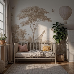 Könnte beinhalten: Ein Kinderzimmer mit einem Safari-Themen-Wandbild mit einer Giraffe, Bäumen und einem Heißluftballon. Ein weißes Kinderbett mit einer grauen Decke und rosa und gelben Kissen steht auf einem hellen Teppich. Eine Topfpflanze und eine weiße Kommode vervollständigen die Szene.