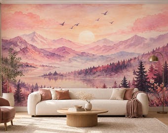 May include: A wall mural featuring a watercolor landscape of pink and purple mountains, a calm lake, and a forest of pine trees under a soft sunset sky with birds. The scene is displayed behind a white sofa, a round wooden coffee table, and a floor lamp.