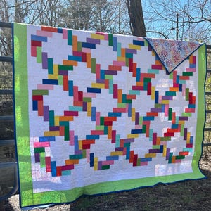 Handmade reversible custom queen-sized Jelly Roll Twist quilt.