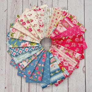 以下が含まれることがあります： 花柄や模様のデザインが施された布の正方形の円形配置。生地は、バラ、スクリプト、幾何学模様をピンク、青、クリーム色で表現しています。明るい木材の表面に配置されています。