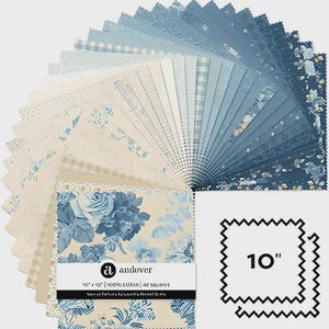May include: A stack of 42 fabric squares, each measuring 25.4 cm by 25.4 cm, arranged in a fan shape. The fabric pieces feature various blue and cream patterns, including floral prints, gingham, and stripes. A paper band labelled Andover is included.