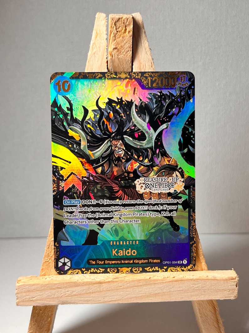May include: A collectible trading card featuring Kaido, a character from the anime and manga series One Piece. The card is holographic and features a colourful illustration of Kaido with the text "DON!! - 6 (You may return the specified number of DON!! cards from your field to your DON!! deck): If your Leader has the (Animal Kingdom Pirates) type, K.O. all Characters other than this Character."