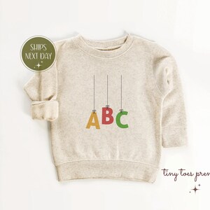 Camiseta con el alfabeto ABC para niños pequeños, camiseta de aprendizaje temprano para niños, regalo para educación preescolar, linda camiseta con letras colgantes para bebé, camiseta de fonética