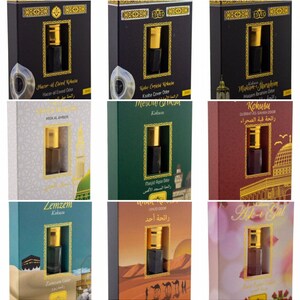 May include: Assortment of small, rectangular boxes with gold trim, each containing a small bottle of perfume. The boxes feature images of Islamic religious sites and Arabic text. The text on the boxes includes the names of the perfumes, such as "Hacer-el Esved Kokusa" and "Zemzem Kokum".