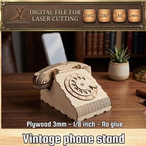 Puede incluir: Un soporte para teléfono de madera clara con forma de teléfono de disco antiguo, con un auricular apoyado en la parte superior. El soporte está diseñado para madera contrachapada de 3 mm y sostiene un smartphone en la ranura trasera.