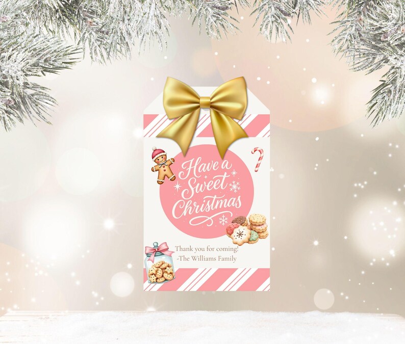 May include: A Christmas gift tag with a gold bow at the top. The tag has a pink and white striped background and features a gingerbread man, candy cane, and the text "Have a Sweet Christmas". A jar of cookies and a stack of cookies are also shown.