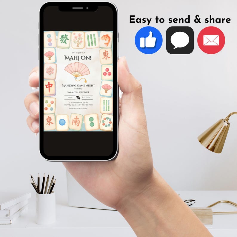 May include: A smartphone displays a Mahjong game night invitation. The invitation features a fan illustration and Mahjong tiles. The phone is held in a hand, with social media icons and the text "Easy to send & share" visible.