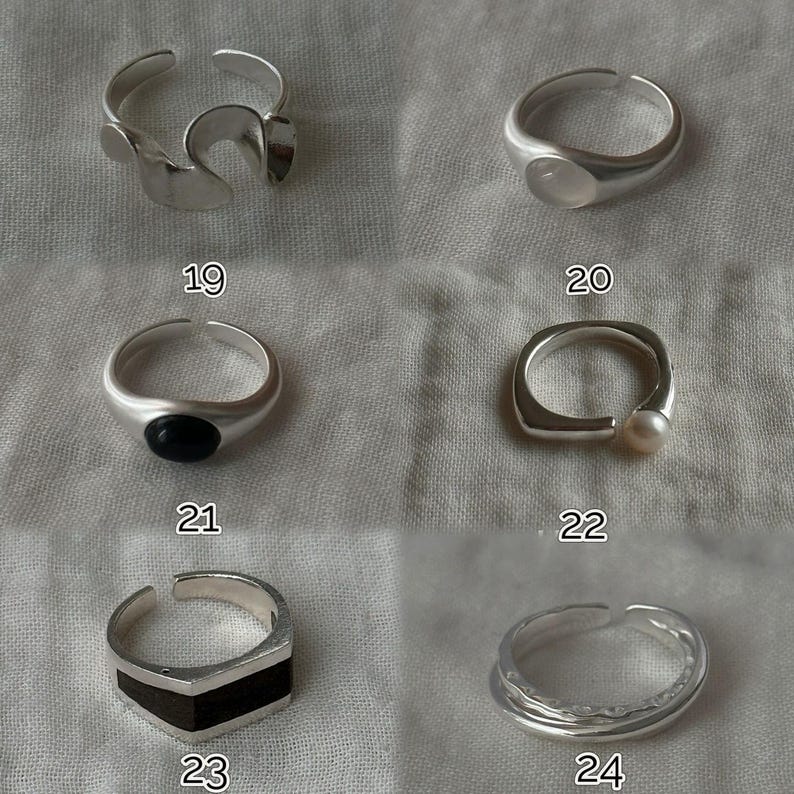 May include: A collection of silver rings, each with a unique design. One ring features an abstract shape, another has a rounded stone, and a third has a black stone. Other rings include a pearl and a geometric design. Numbers 19, 20, 21, 22, 23, and 24 are visible.