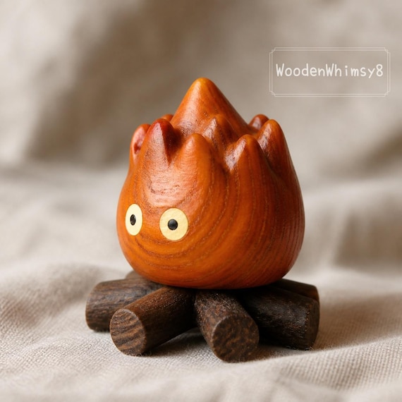 A hand-carved rosewood flame sculpture with a magnetic base — abstract fire frozen in warm wood grain, works on a desk or in a car.