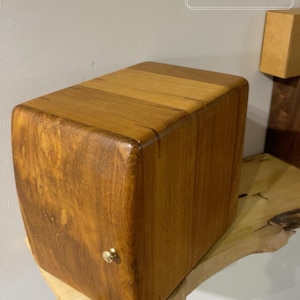 May include: A set of three ceramic mugs with a speckled, matte finish. The mugs are in shades of cream, light gray, and dark gray. Each mug has a simple, minimalist design and a rounded handle.