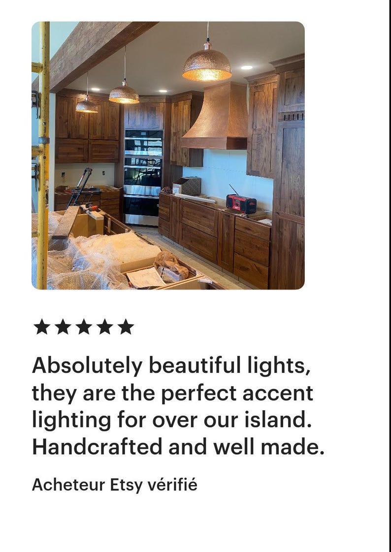 May include: A kitchen with wooden cabinets, a range, and a copper range hood. Three copper pendant lights hang above the island. The text says, "Absolutely beautiful lights, they are the perfect accent lighting for over our island. Handcrafted and well made."