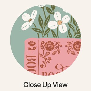 May include: A close-up view of a pink book with floral illustrations and the word "BOOK" in large letters. The background features white flowers and green leaves against a teal backdrop. The text "Close Up View" is at the bottom.