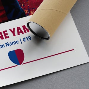 May include: A white poster with the text "MINE YAM" in red and "Team Name | #19" in blue. A blue and maroon shield logo is below the text. The poster is rolled up in a brown cardboard tube.
