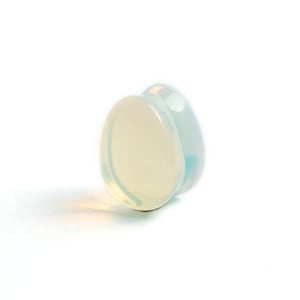 May include: A white opal ear gauge plug with a slightly iridescent finish.