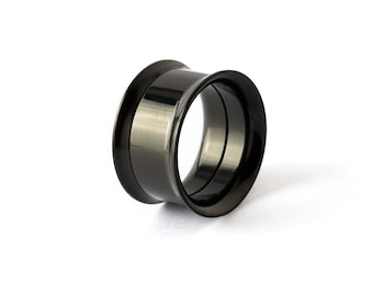 May include: A polished black ear tunnel plug with a smooth, cylindrical shape and flared edges. The metal surface has a reflective, dark finish that catches the light, creating a sleek, uniform appearance for this body jewelry piece.