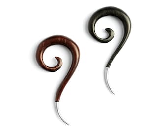 May include: Two spiral-shaped ear gauges made of wood. One gauge is dark brown and the other is black. Both pieces feature a smooth, curved design that tapers into a thin, silver-colored metal tip at the bottom end of each spiral shape.