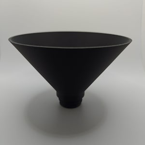 May include: A black, cone-shaped lampshade with a smooth, matte finish.
