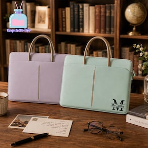 Peut inclure: Deux sacoches pour ordinateur portable rectangulaires avec des poignées arrondies, l'une violet clair et l'autre vert menthe. Le sac vert menthe présente un monogramme noir avec la lettre M et le nom McCarthy imprimés en bas à droite.